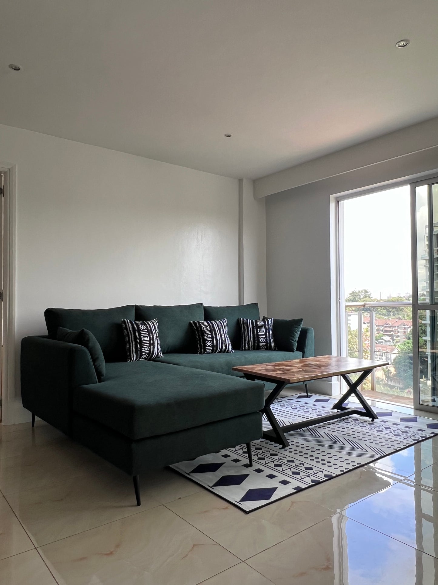 Green L-shape sofa for ksh 90,000 with 40 D cushions