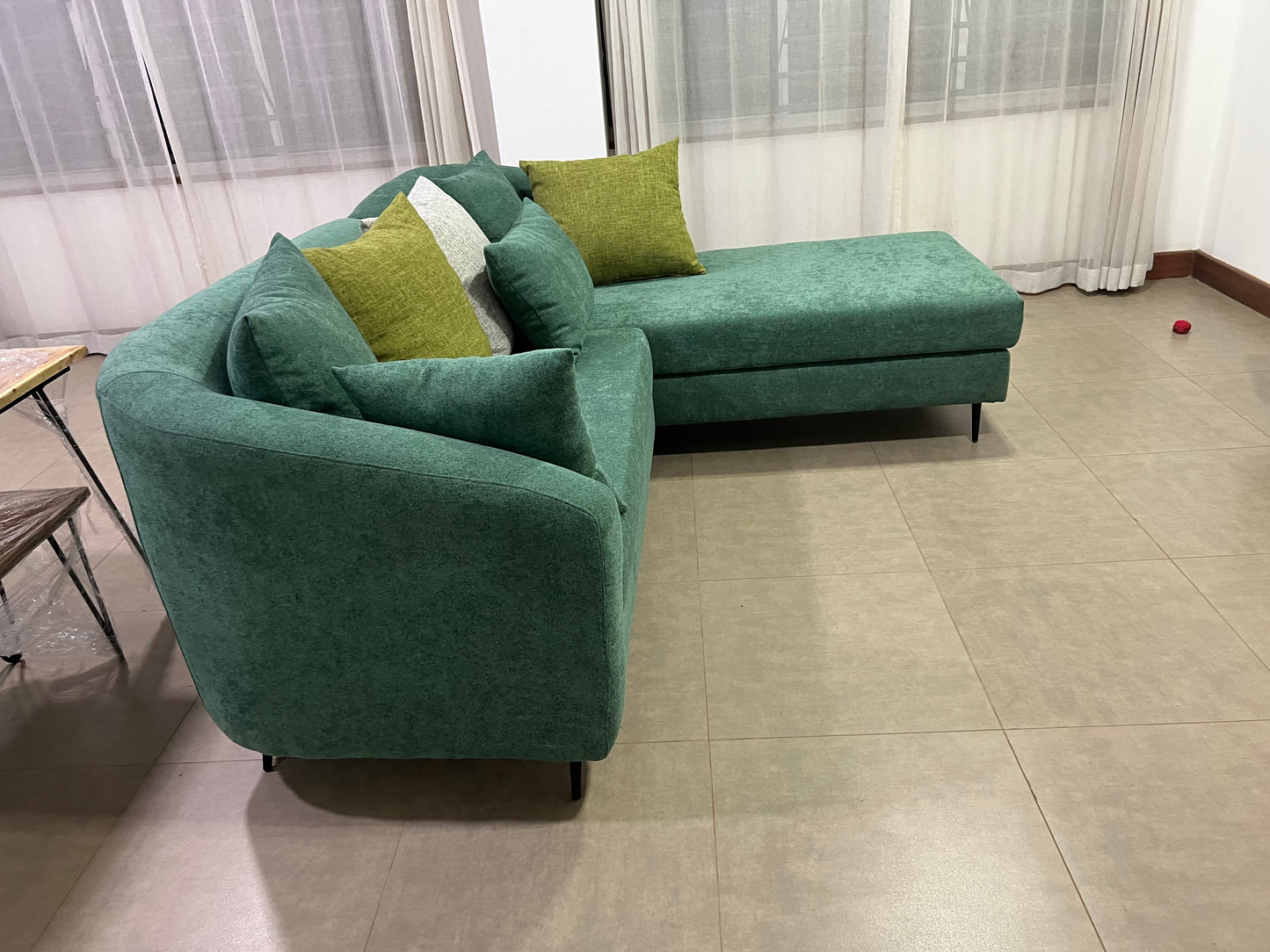 Green l-shape sofa with extra throw pillows