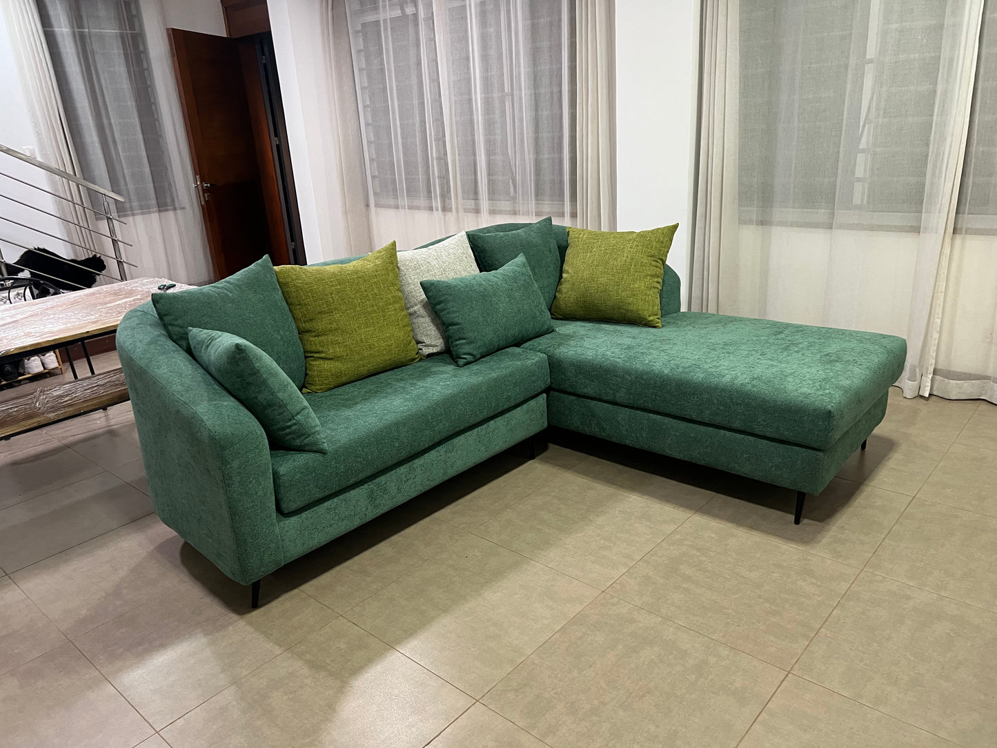 Green l-shape sofa with extra throw pillows