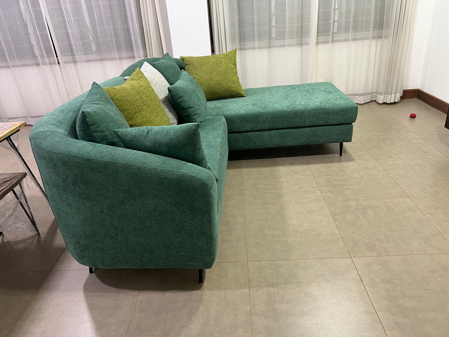 Green l-shape sofa with extra throw pillows